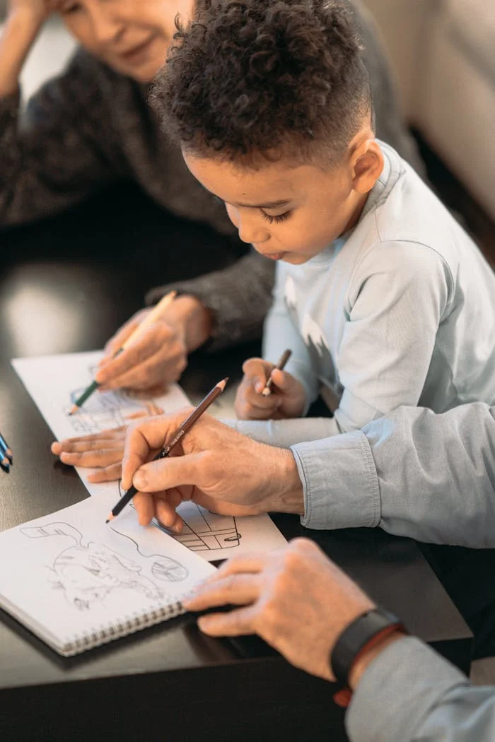 services-01 A senior couple and child enjoying drawing together at home, fostering creativity.